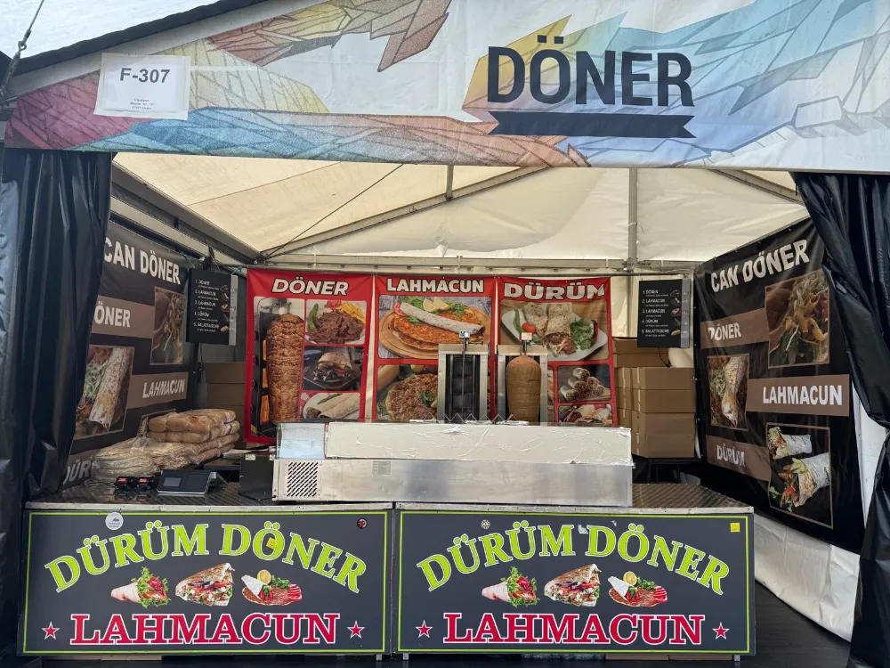 Beleuchteter Verkaufsanhänger von Can-Döner am Abend auf einem Festival
