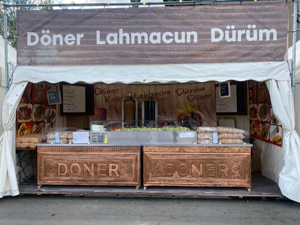 Beleuchteter Can-Döner Stand am Abend